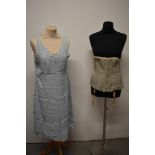 An early 20th century corset in grey and a 1940s camisole in powder blue.