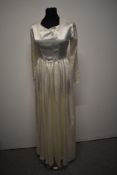 A vintage late 1940s/1950s wedding dress having long sleeves, self covered buttons to reverse and