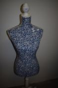 A modern female body form in blue floral design.