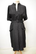A late 1940s black dress having faux pocket decoration to box pleated skirt with button detail to