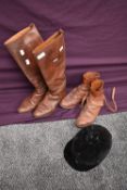 Two pairs of tan leather vintage riding boots having leather soles and a velvet riding hat, circa