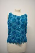 A vintage 1960s aqua blue top, having heavy beading and sequins throughout.