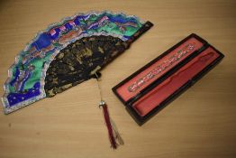 A mid 19th century fan with original box, having hand painted oriental scenes of people gathering,