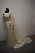 A 1940s wedding dress having printed floral design, square neckline, long sleeves and press stud
