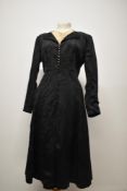 A stunning late 1920s/ 1930s black dress having deeply textured floral pattern, filigree metal