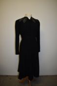 A late 1930s black wool day dress having buttons to nape and cuffs with contrasting embroidery to