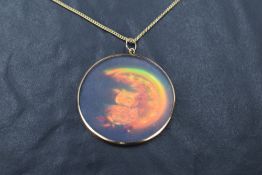 A yellow metal mounted holographic pendant, of circular form depicting a jewel encrusted owl and