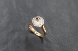 A yellow metal (thought to be gold) and white stone solitaire ring, the brilliant-cut white stone