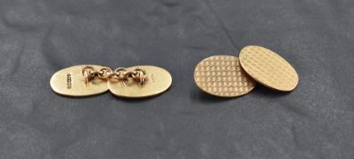 A pair of 9ct gold cufflinks of oval form having engine turned chequered decoration and chain