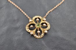 An Edwardian style yellow metal pendant stamped 9ct having central peridot with seed pearl