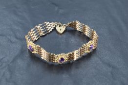 A 9ct gold five-bar gate bracelet, having three unusual amethyst set scrolled links, the heart-