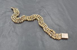 A Yellow metal three-strand bracelet, with pierced circular and twisted links finishing with a