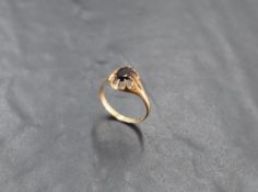 A 9ct gold and garnet gypsy type solitaire ring, with central oval-cut stone, the shank marked