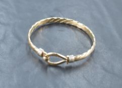 A 9ct gold bangle, of twisted form with eyelet and hook fastening, marked 375, 6.5cm, 25.3grams