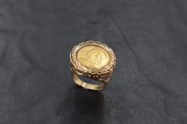 A 9ct gold mounted half sovereign ring, with traditional engine-turned setting and pierced mount and