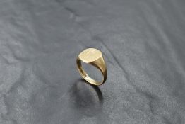 A gent's 9ct gold signet ring having engraved decoration to plain panel, size W/X & approx 7.4g