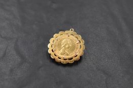 A yellow metal mounted 1979 sovereign coin pendant, of lobed circular form with engine-cut