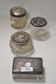 A group of four silver-topped glass dressing table wares, to include two hair tidies, silver
