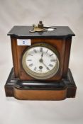 An antique mahogany cased mantel clock having enamel face with Roman numerals (AF) with key.