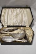A case containing a selection of HM silver dressing table items, most damaged