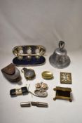A selection of items, including travel ink wells in case, a bell cast from metal from a German