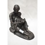 A bronze effect figurine of a mother reading with child.