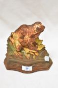 A vintage cast iron door stop in the form of a frog, age related patina.