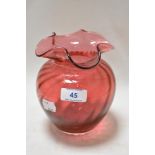 A Dartington cranberry glass vase having fluted rim and ribbed body, marked to underside.