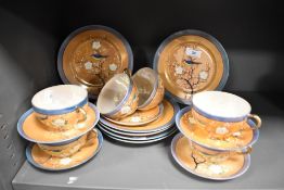 An assortment of Japanese hand painted lustre finish cups, saucers and plates.