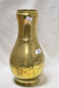 A 1930s Japanese brass vase having embossed flying geese and foliate design.