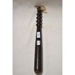 A vintage stained wooden truncheon having ribbed handle.