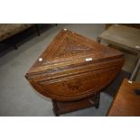 A late Victorian oak tri-form occasional table having demi lune drop flaps and carved decoration