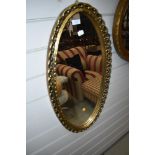 A gilt frame oval wall mirror