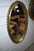 A gilt frame oval wall mirror