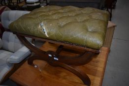 A reproduction Savanorola style stool having worn leather button seat