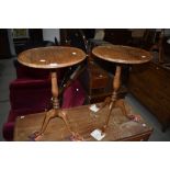 A pair of period style oak occasional tables having circular top, turned colum and triple splay