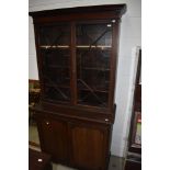 A late 19th or early 20th Century mahogany bookcase having astral glazed top over double cupboard