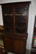 A late 19th or early 20th Century mahogany bookcase having astral glazed top over double cupboard