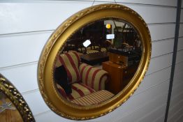 A gilt frame oval wall mirror