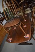 A vintage dark stained Ercol dining table and set of six (five plus one) similar hoop and stick
