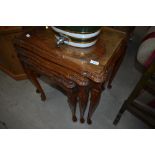 An early to mid 20th century walnut nest of three tables