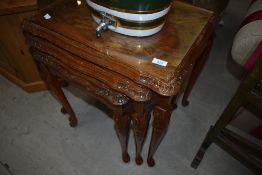 An early to mid 20th century walnut nest of three tables