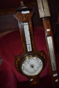 An Edwardian mahogany and inlaid barometer of shield form