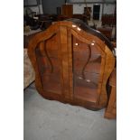 An Art Deco walnut china cabinet having shaped design