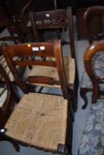 A pair of Victorian stained frame rail back kitchen chairs with later strung seats