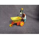 A 1950's Louis Marx clockwork and tinplate Goofy The Gardener, Goofy pushing barrow