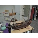 A wooden scale model Galleon having extensive rigging and cannon decoration, on wooden stand