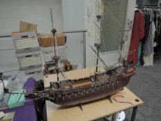 A wooden scale model Galleon having extensive rigging and cannon decoration, on wooden stand