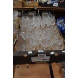 A large quantity of cut glass drinking glasses of assorted sizes.