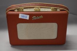 A vintage mid century Roberts transistor radio in red.